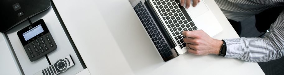 tyler-franta-iusJ25iYu1c-unsplash Immagine di scrivania vista dall'alto con uomo davanti al Pc